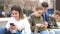 Group of boys and girls teenager addicted in their phones sitting on bench outdoors