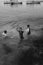 A group of boys is playing water on the beach