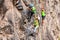 Group Of Brave Climbers Climbing A Rock Wall