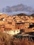 Group of brick houses, which are part of a neighborhood, is guarded by an imposing mountain.