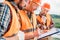 group of builders in hard hats and reflective vests looking