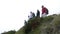 Group business colleague in team building celebrating the achievement rising arms on edge of mountain peak successful people -