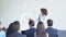 Group Of Business People Asking Question To Businesswoman Leading Presentation In Modern Conference Hall