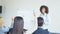 Group Of Business People Asking Question To Businesswoman Leading Presentation In Modern Conference Hall