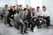 Group of business people in formalwear sitting at the chairs in conference hall