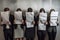 Group of business people holding paper sheets in front of their faces. Young people hiding their faces behind resume paper, AI