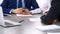 Group of business people and lawyer discussing contract papers sitting at the table, closeup. Businessman is signing