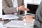 Group of business people or lawyers at meeting discussing contract papers. Woman pointing into laptop computer monitor