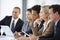 Group Of Business People Listening To Colleague Addressing Office Meeting