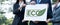 Group of business people stand united, holding eco-friendly idea. Gyre