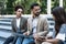 Group of business people walk outside in front of office buildings. Businessman and two businesswomen sharing experience ideas and