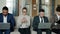 Group of businessmen and businesswomen using smartphone and laptops in hotel lobby