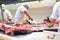 group of butchers works in a slaughterhouse and cuts freshly slaughtered meat (beef and pork) for sale and further processing as