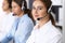 Group of callcenter operators at work. Focus at beautiful business woman in headset