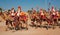 Group of the camel riders in uniforms going to the Desert Festival