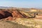 A group of cars and tourists at the beginning of the Paint Cove Trail in Painted Hills