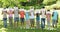 Group of casual young friends holding smiley faces over their faces