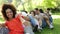 Group of casual young friends sitting in a row messing