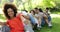 Group of casual young friends sitting in a row messing