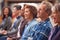 Group Of Casually Dressed Businessmen And Businesswomen Listening To Presentation At Conference