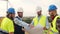 Group of Caucasian male engineers looking at a blueprint in a windmill park