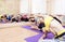 Group of Caucasian Women Stretching Indoors on Purple Sport Mats