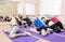 Group of Caucasian Women Stretching Indoors on Purple Sport Mats