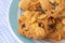 Group of cereal cookies in blue plate on table with tablecloth. Freshly baked