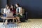 Group of charming beautiful Asian women using smartphone and laptop, chatting on sofa at cafe, modern lifestyle