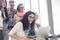 Group of cheerful businesspeople with laptop at desk in creative office