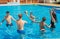 Group of cheerful couples friends playing water volleyball