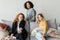 Group of cheerful friendly girls relaxing on soft comfortable sofa