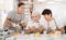 Group of cheerful people painting ceramic dishware in pottery class