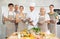 Group of cheerful people posing with male chef during cooking class