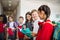 A group of cheerful small school kids with bags in corridor, talking.