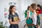 A group of cheerful small school kids with bags walking in corridor.