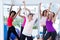 Group of cheerful women exercising with arms raised