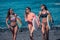 Group of cheerful women with surfboards on beach