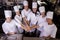 Group of chefs formig hands stack in kitchen