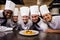 Group of chefs looking at prepared pasta in kitchen