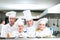 A group of chefs posing with delicious meal in high luxury restaurant.