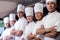 Group of chefs standing in kitchen