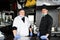 Group chefs standing together in the kitchen at restaurant wearing protective medical mask and gloves in coronavirus new normal