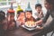 Group of children blowing birthday cake in birthday party singing happy birthday