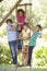 Group Of Children Climbing Rope Ladder To Treehouse