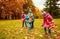 Group of children collecting leaves in autumn park