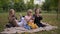 group of children, four little girls having a picnic in the park, looking at phones, concept of addiction to gadgets and