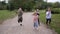 group of children - four little happy girls having fun in the summer park, running along the pedestrian path and