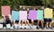 Group of children holding blank banner cover their face