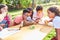 Group of children look at tree bark through a magnifying glass